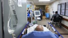 Bald male patient lays in an ER hallway