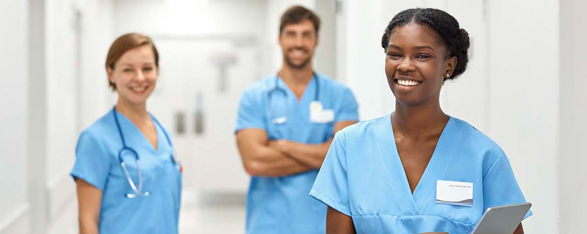 Smiling nurses standing in hospital hallway