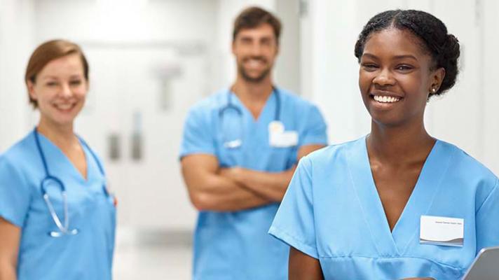 Smiling nurses standing in hospital hallway
